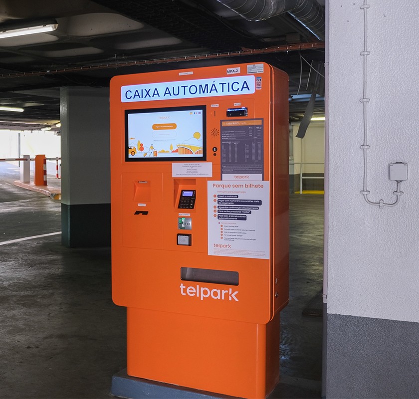 A large and orange BION paying machine in an indoor parking lot