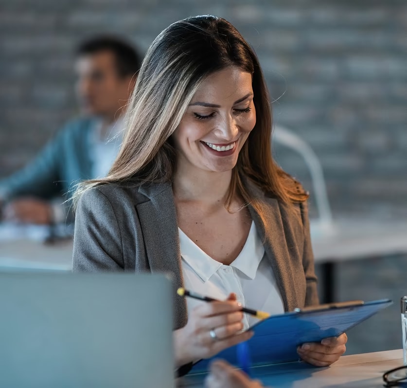A young woman smilling while using a touch pen and a tablet